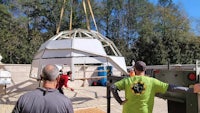 a group of people standing around a large dome